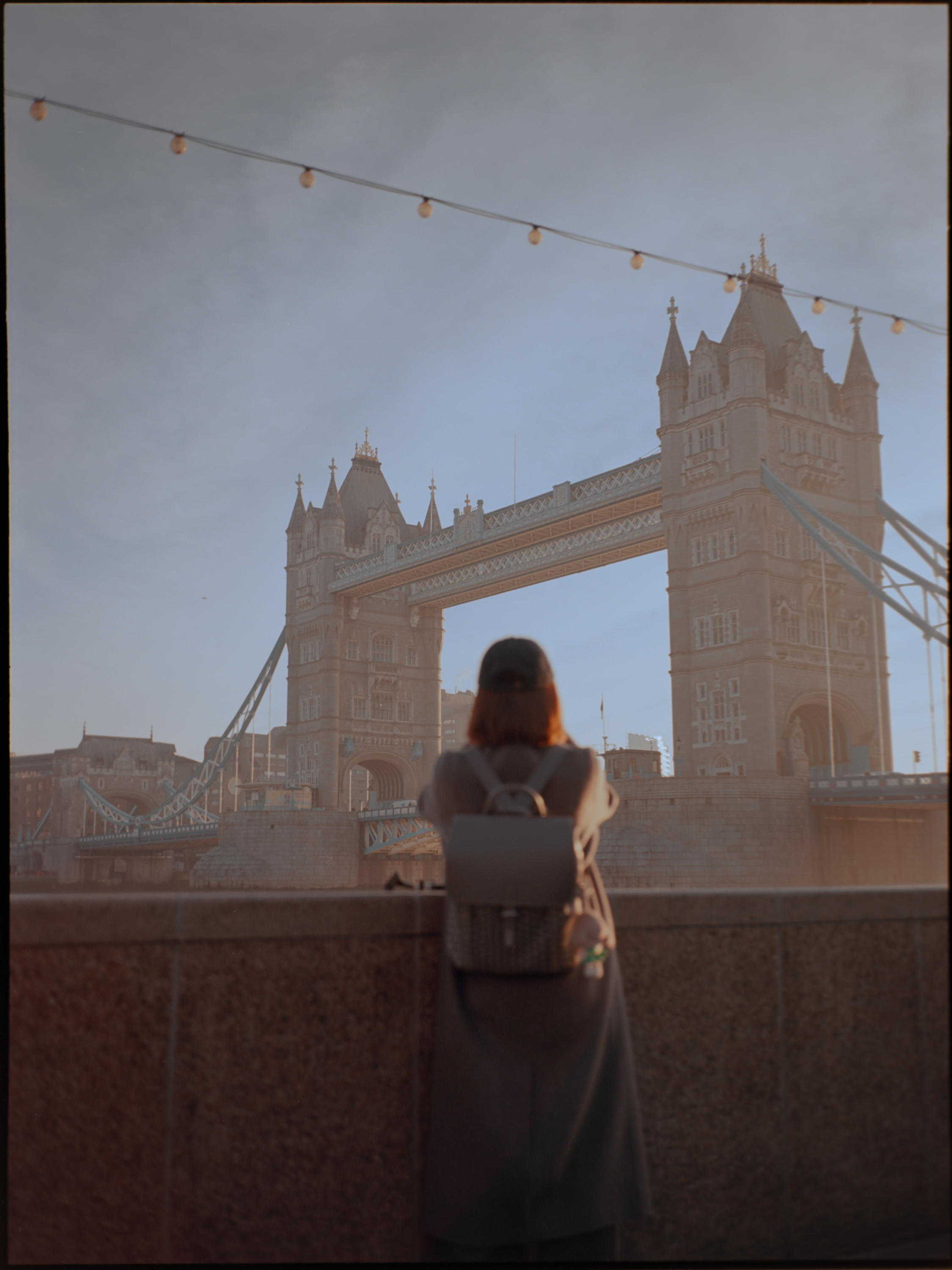 Woman looking out toward Tower Bridge from the south bank promenade — Fujifilm GA645S on Kodak Ektar 100