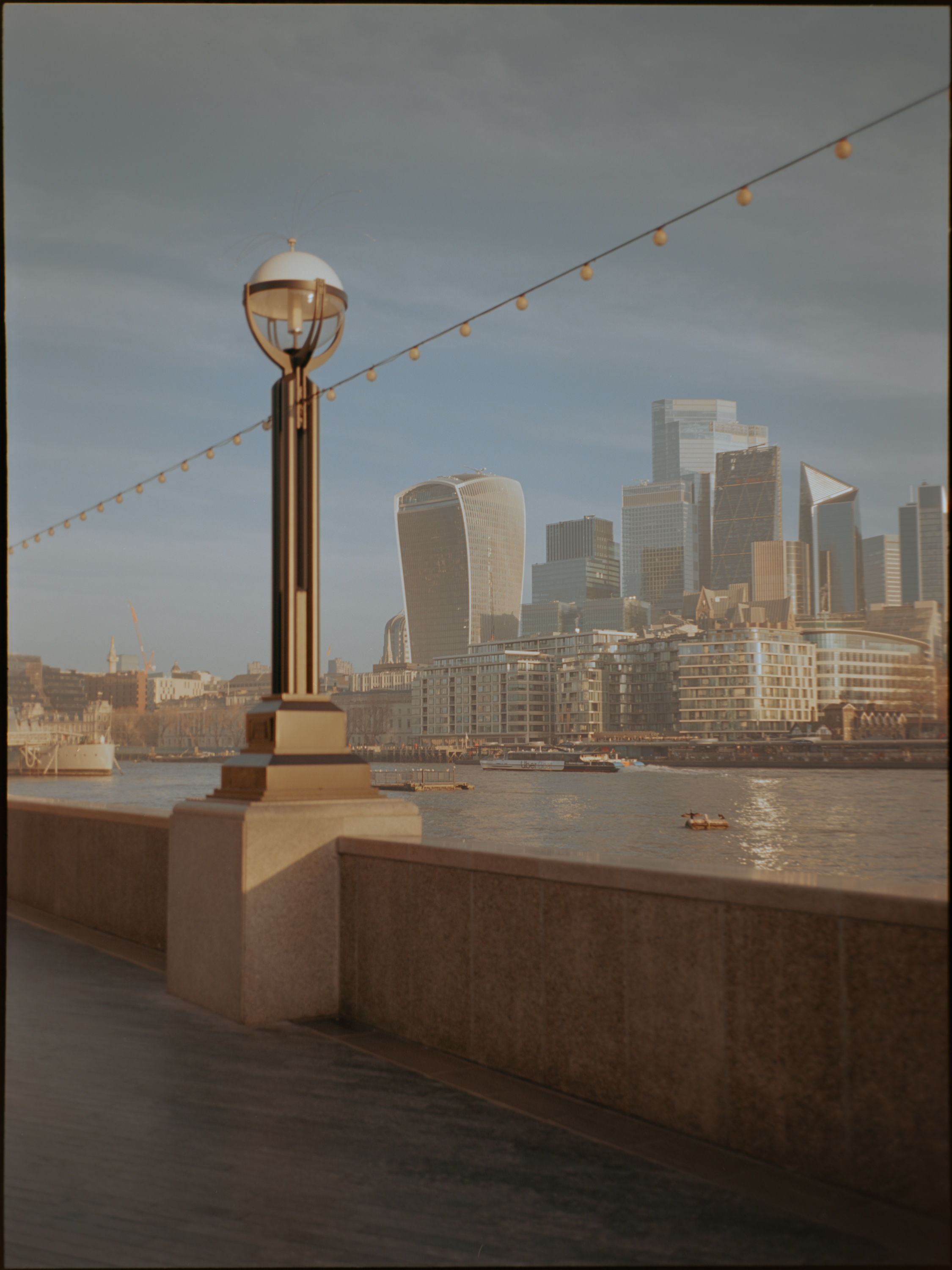 City of London skyline from the south bank with ornate lamp post — medium format film photography