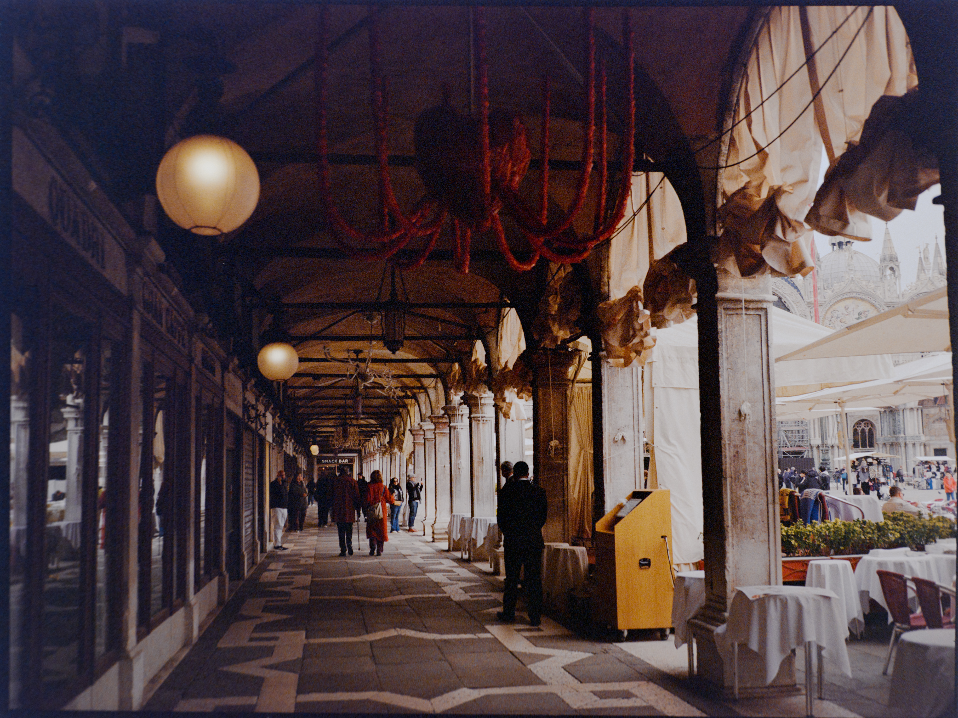 Atmospheric covered arcade walkway with glowing lanterns — Venice on Kodak Gold 200
