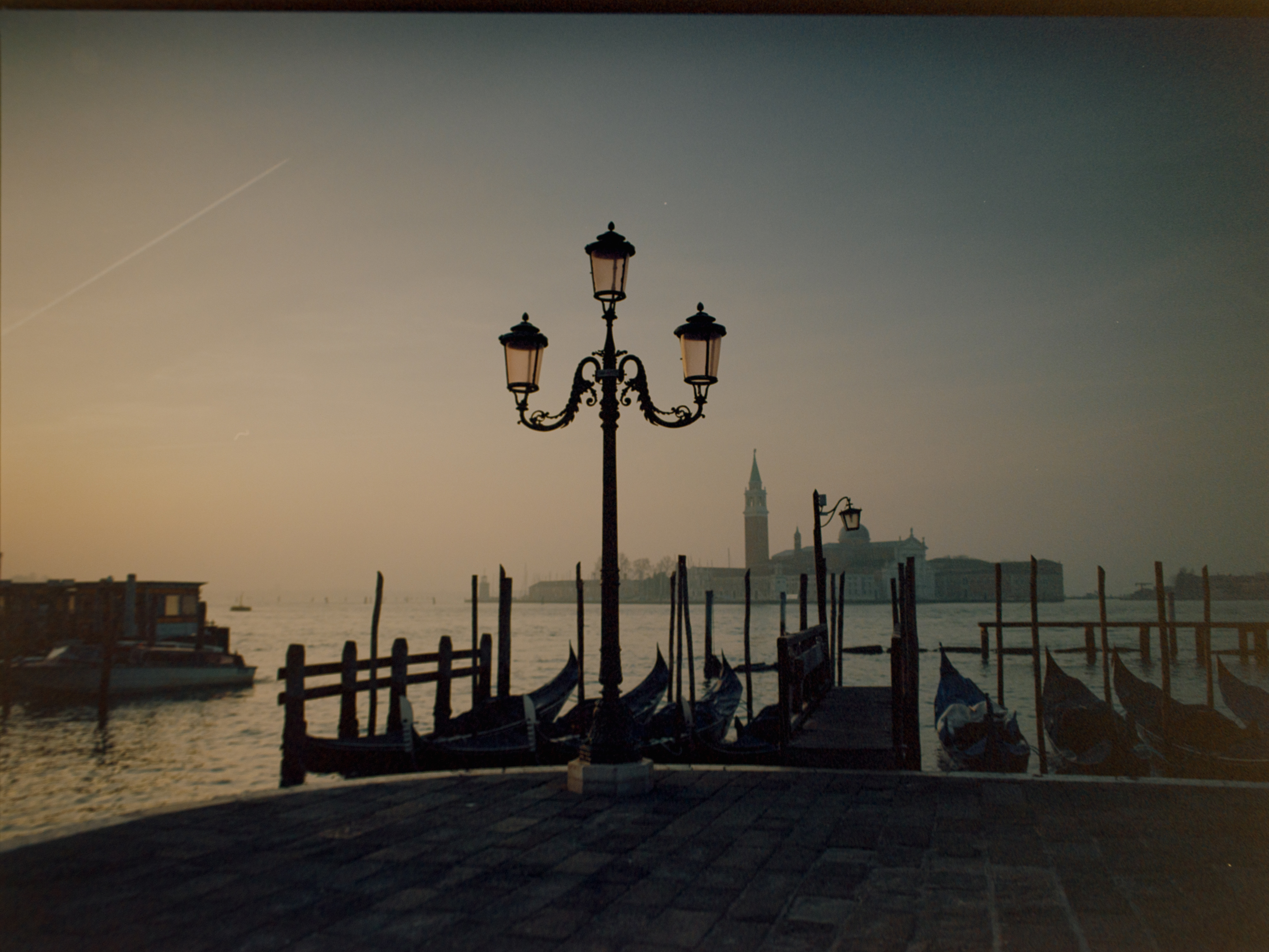 Silhouetted ornate lamp post with moored gondolas and San Giorgio Maggiore at dusk — Venice on Ektar 100
