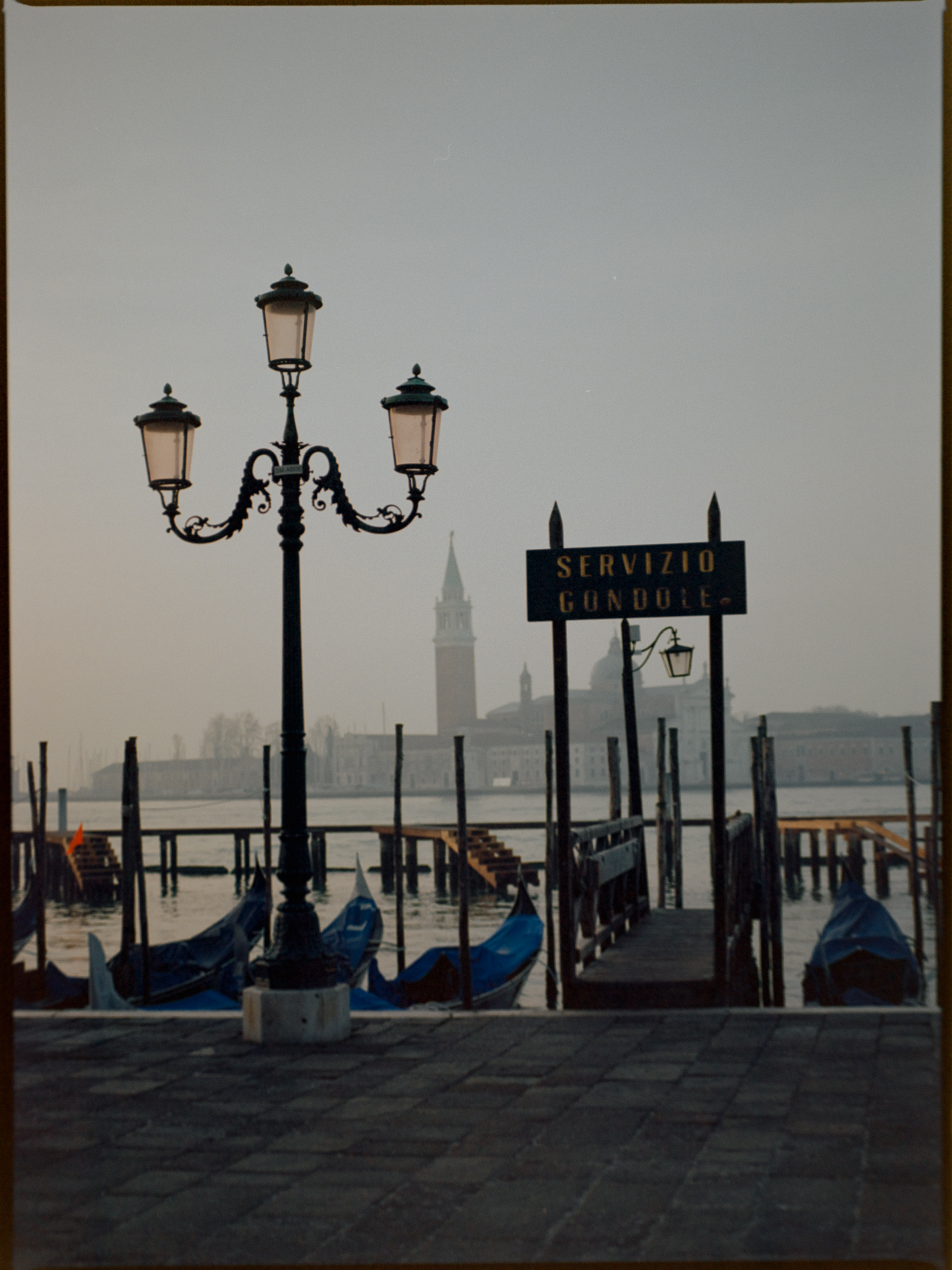 Gondola moorings at the waterfront with San Giorgio Maggiore in the mist — Venice sunrise on Ektar 100