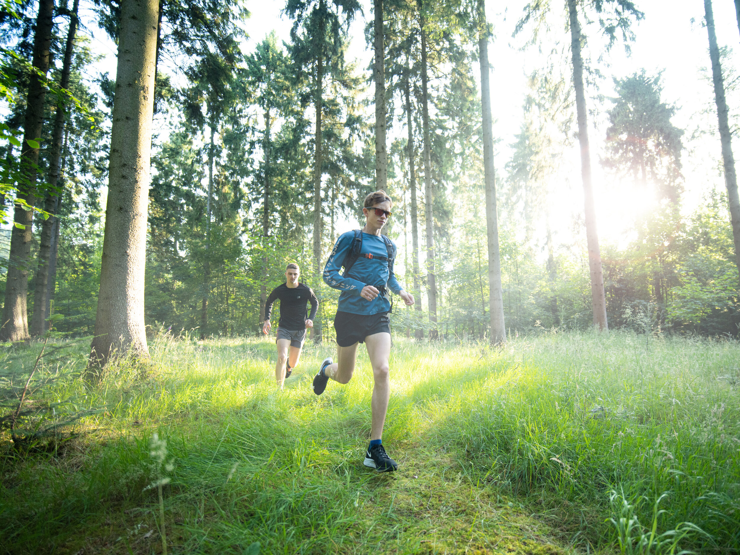trail runners sunlit forest commercial lifestyle photographer london