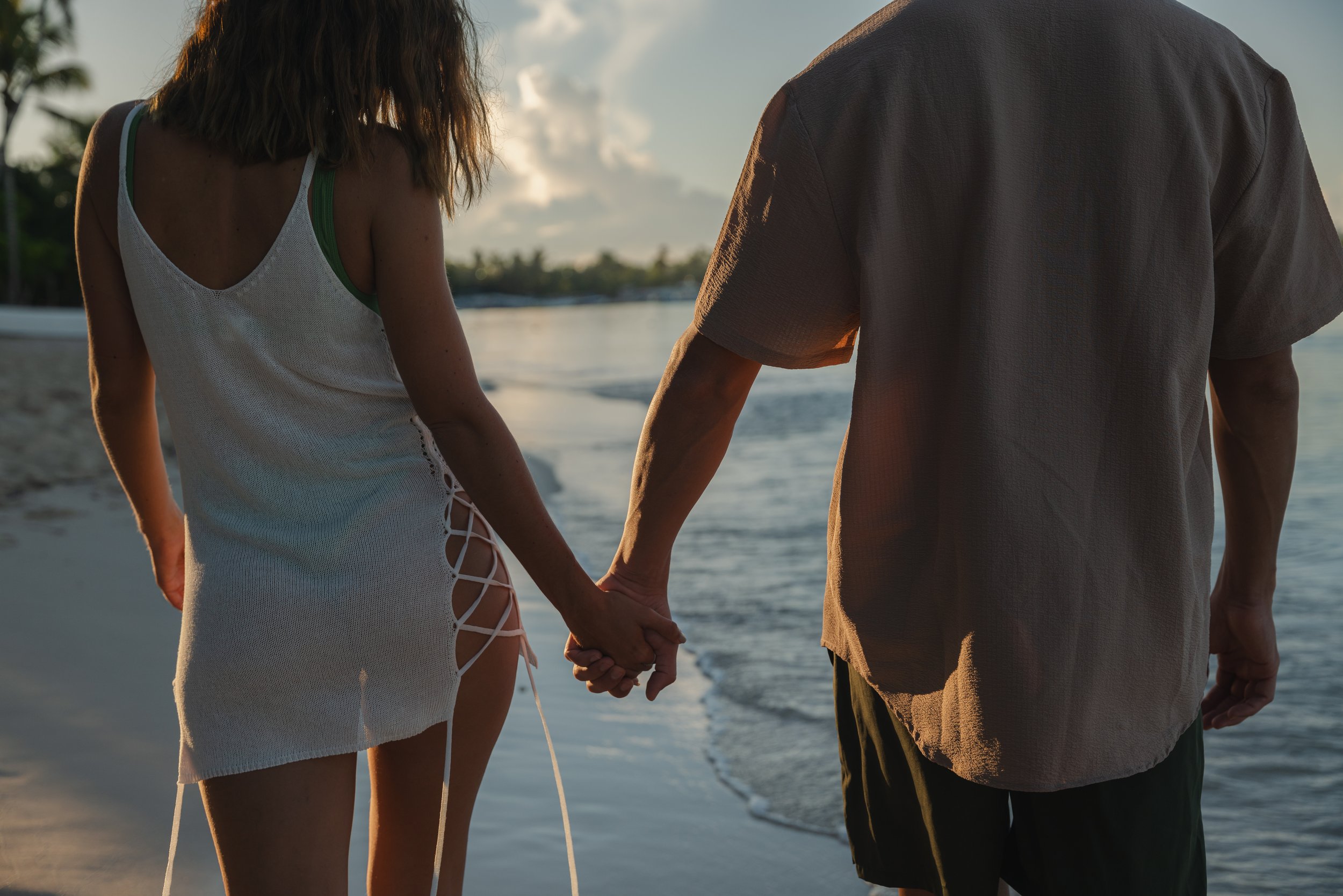 Couple holding hands sunset beach walk Caribbean, lifestyle photographer London